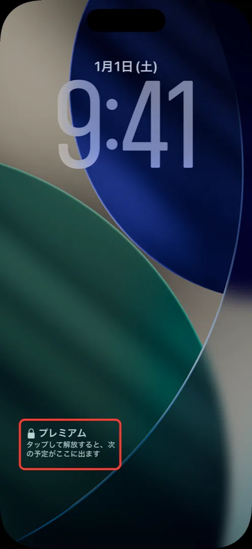 iPhoneのロック画面。時計の下に鍵アイコンと「プレミアム」「タップして解放すると、次の予定がここに出ます」と表示されている