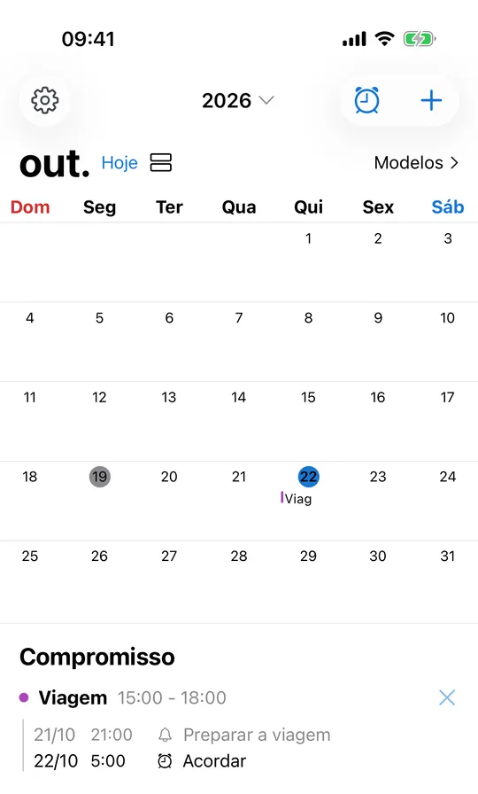 Calendário do CAlarm em outubro de 2026: o compromisso Viagem no dia 22 e, abaixo, o aviso “Preparar a viagem” na noite anterior às 21:00 e o alarme Acordar às 5:00