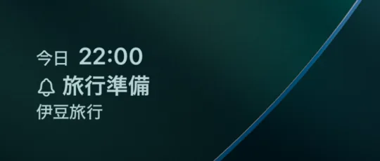 iPhoneのロック画面ウィジェット。「今日 22:00」、ベルのアイコンと「旅行準備」、予定名の「伊豆旅行」が壁紙の上に3行で表示されている